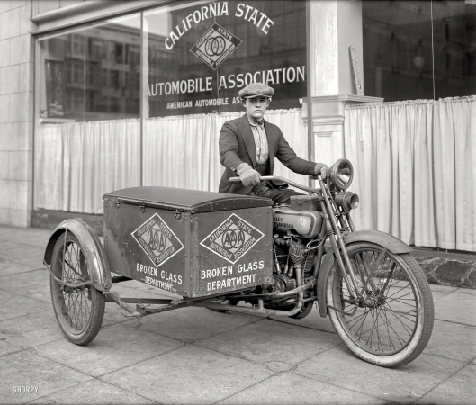 Photo showing: Glass Wrangler -- San Francisco ca. 1920s. Young man on Harley-Davidson motorcycle --
California State Automobile Association 'Broken Glass Department' patrol.