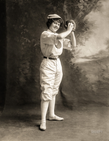 Photo showing: A Perfect Game -- May 14, 1913. Young woman in pitching stance, full-length studio portrait, wearing a baseball uniform.