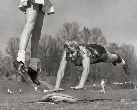 Photo showing: Ladies vs. Tomboys -- April 9, 1955. Atlanta, Georgia. Linda McConkey, of the Lorelei Ladies
softball team, diving for third base during an exhibition game; and Jerrie Rainey,
playing third base for the Atlanta Tomboys, as she jumps for the ball.