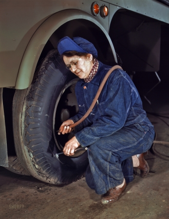 Photo showing: In Like Kwint -- February 1943. Milwaukee, Wisconsin. Mrs. Angeline Kwint, age 45,
an ex-housewife working for the Heil Company, checking the tires of trailers.