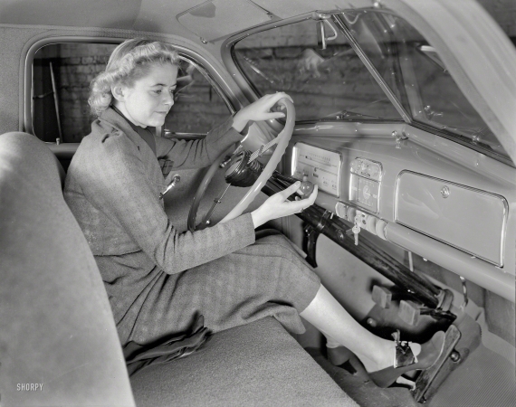Photo showing: Easy Driver -- 1937. Woman demonstrating gearshift operation in Pontiac sedan.