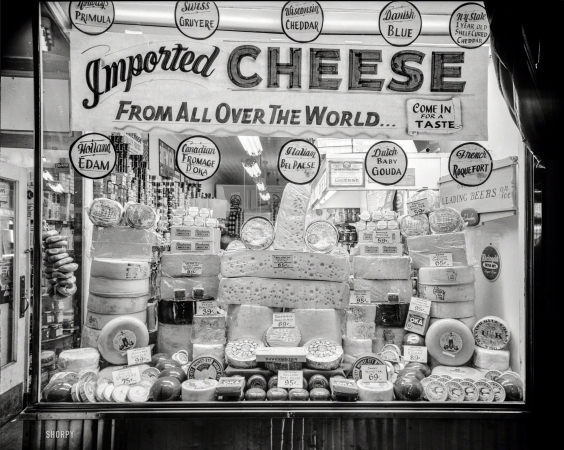 Photo showing: Come In for a Taste -- New York circa 1948. Window display of imported and domestic cheeses.