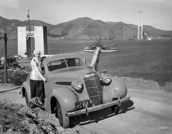 Photo showing: Bridge Out! -- San Francisco, 1935. Oldsmobile coupe and Golden Gate Bridge under construction.