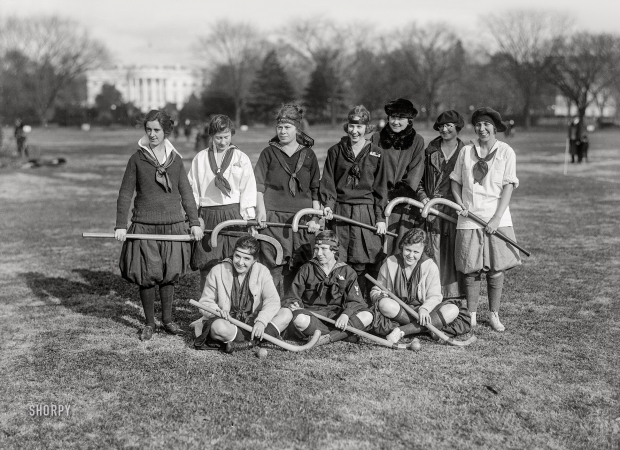 Photo showing: Eight Bloomers -- Washington, D.C., circa 1922. Girls' field hockey group on the Ellipse, White House in background.