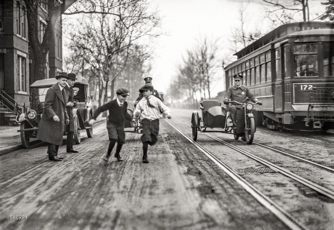 Photo showing: Kid Crossing -- Washington, D.C., circa 1922. Children, police motorcycles with sidecars, and streetcar in street.
