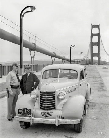 Photo showing: Crossing Guard. -- San Francisco, 1937. Don Lee Oldsmobile on Golden Gate Bridge with police officer.
