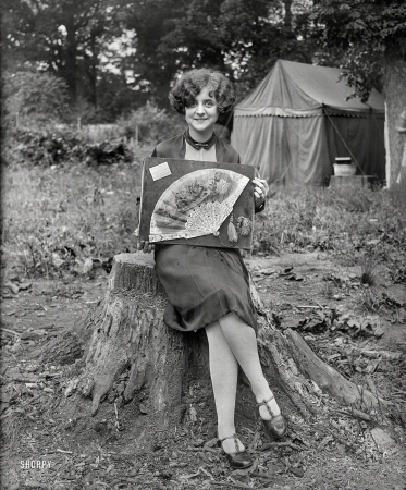 Photo showing: Her Own Biggest Fan -- Washington, D.C., or vicinity, 1927. Woman at campsite with fan display.