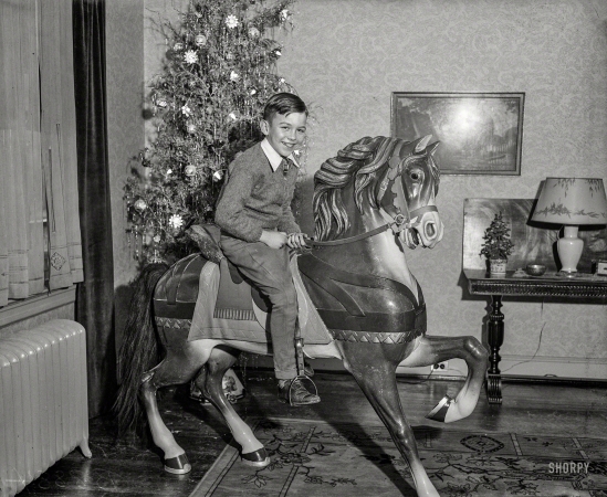 Photo showing: Pony Boy -- Washington, D.C., circa 1935. Boy on toy pony next to Christmas tree.