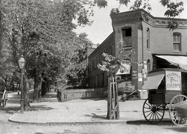 Photo showing: Corner Store. -- Washington, D.C., circa 1901. View of 21st Street N.W., east side,
looking north from E Street, with dairy cart at the curb in front of a corner shop.