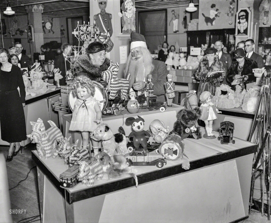 Photo showing: Fala La -- December 1934. Mrs. Roosevelt, on a Christmas shopping tour, inspecting
an assortment of toys at a Washington, D.C., department store.