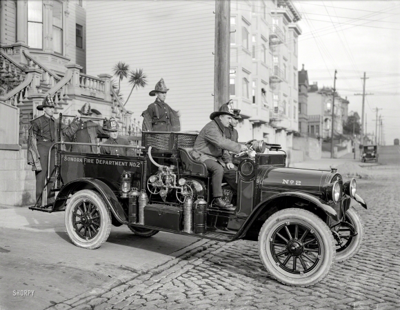 Photo showing: Where's the Fire? -- San Francisco, 1921. Sonora Fire Dept. REO truck at Engine Co. 15 firehouse, California Street.