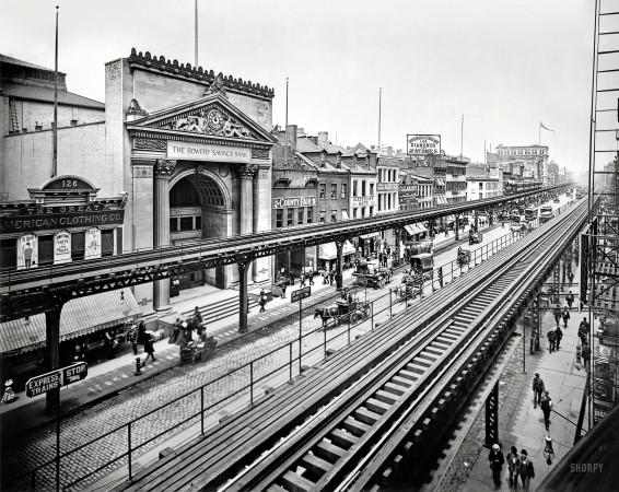 Photo showing: All Along the El -- Manhattan circa 1900. The Bowery, New York. Tracks of the Third Avenue El passing the Bowery Savings Bank.