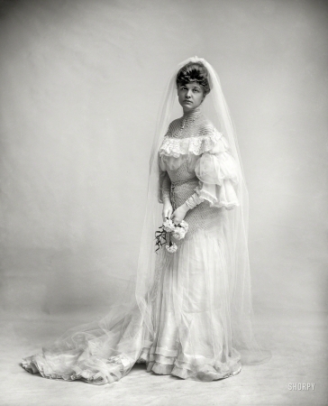 Photo showing: Bride and Gloom -- Circa 1910. Woman in wedding dress holding flowers.