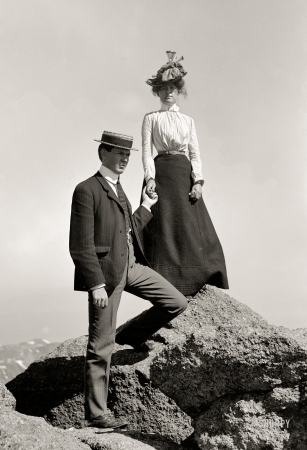 Photo showing: Love on the Rocks -- Circa 1910. Young couple on rock holding hands, full-length portrait.
