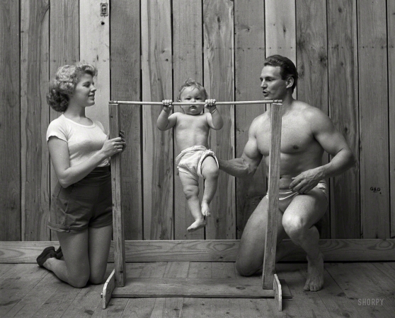 Photo showing: Lil Champ -- June 1947. Bodybuilder Gene Jantzen with wife Pat and 11-month-old son Kent.