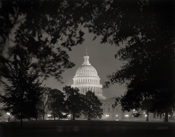 Photo showing: Dome Noir -- Washington, D.C., circa 1940. U.S. Capitol exteriors. Dome of Capitol through trees at night.