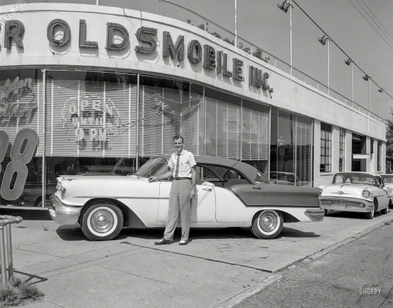 Photo showing: Golden Rocket -- Columbus, Georgia, circa 1957. Oldsmobile dealer. The Golden Rocket 88 Holiday Sedan for '57.