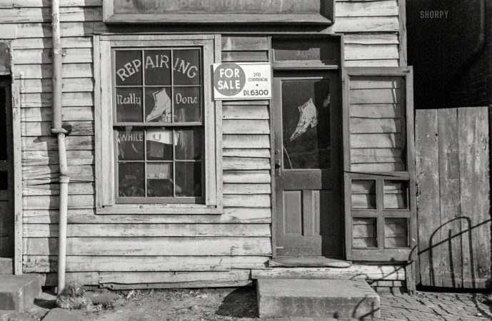 Photo showing: Repairing Neatly Done -- January 1938. Washington, D.C. Shoe shop on L Street.