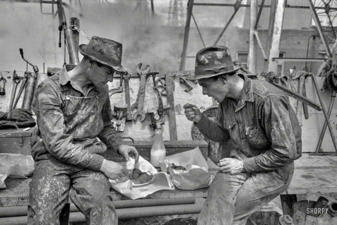 Photo showing: A Working Lunch. -- April 1939. Kilgore, Texas. Oilfield workers eating lunch.
