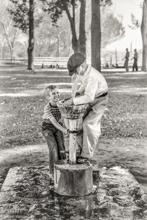 Photo showing: Little Squirt -- July 1941. Fun at the water fountain. Fourth of July picnic in Vale, Oregon.