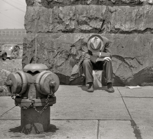 Photo showing: Two of a Kind. -- July 1941. Chicago. Man seated on corner of Jefferson Street and Vernon Park Place.