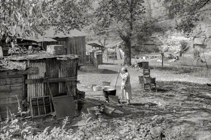 Photo showing: Hot Sheets -- September 1938. Old and sick, mine foreman's wife does washing in front yard. South Charleston, W.Va.