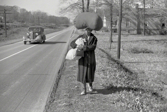 Photo showing: Wash Walker -- November 1939. Negro woman carrying laundry home along highway between Durham and Mebane, North Carolina.