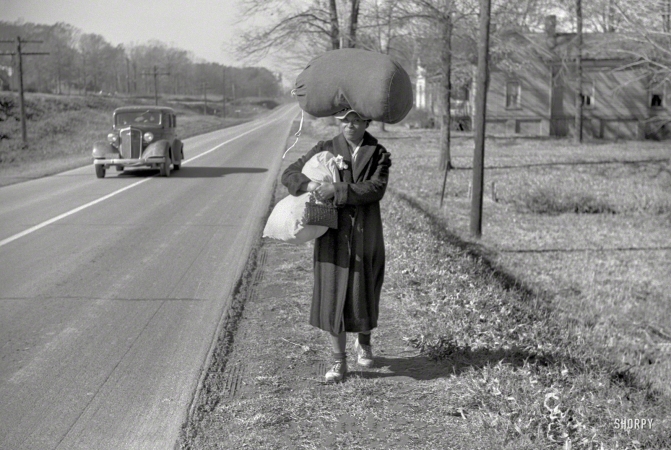 Photo showing: Wash Walker -- November 1939. Negro woman carrying laundry home along highway between Durham and Mebane, North Carolina.