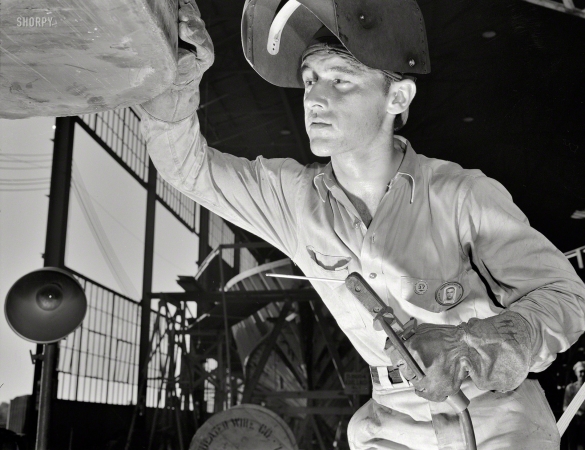 Photo showing: Arc Story -- July 1942. Arc welder working on a steel ramp boat. Higgins Industries, New Orleans. 