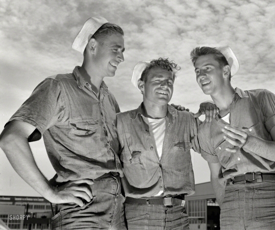 Photo showing: Jokey Salts -- August 1942. Sailor mechanics at the naval air base in Corpus Christi, Texas,
laugh heartily over a good story between servicing operations on Navy planes.