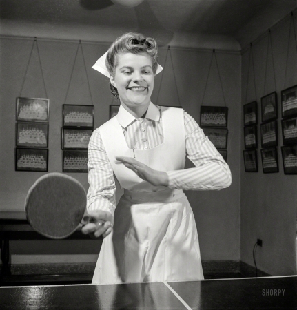 Photo showing: This Wont Hurt a Bit -- November 1942. Babies' Hospital, New York. At the ping-pong table in the game room,
Susan Petty, student nurse, enjoys a bit of relaxation after a busy day's work in the wards.