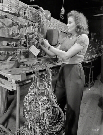 Photo showing: On the Grid -- December 1942. Checking electrical wiring assemblies
for B-17F (Flying Fortress) bombers at the Boeing plant in Seattle. 