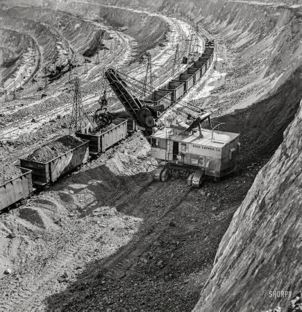 Photo showing: War Ore -- November 1942. Loading copper ore at the open-pit mining operations of Utah Copper Company at Bingham Canyon.
