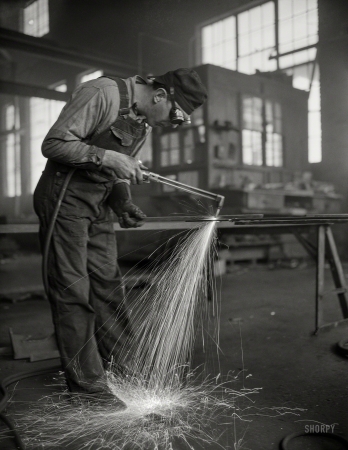 Photo showing: Keep Em Sailing -- May 1942. Denver, Colorado. Welder fabricating hull plates for Navy transports.