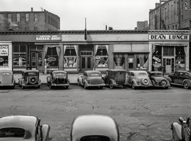 Photo showing: Zines and Beans -- November 1938. Capitol Avenue storefronts, Omaha, Nebraska.