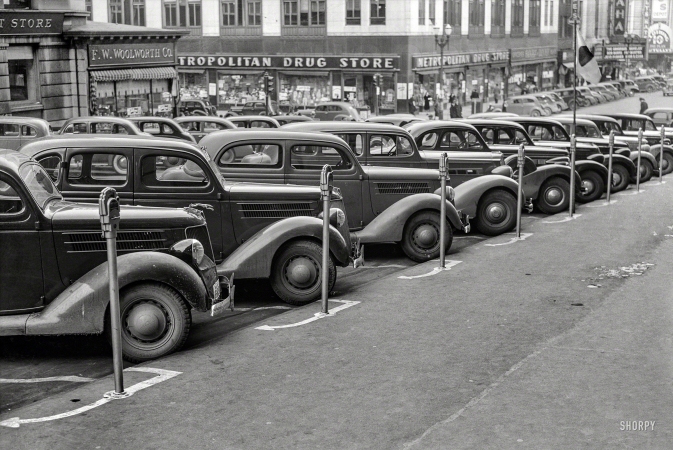 Photo showing: Omaha Stakes -- November 1938. Omaha, Nebraska. Cars parked diagonally along a row of parking meters.