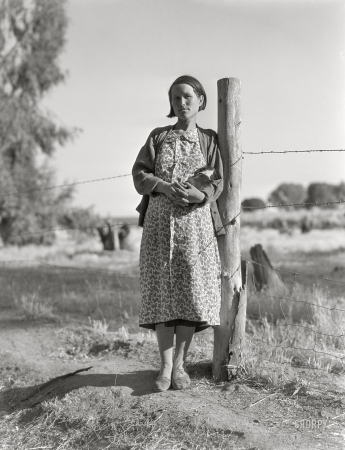 Photo showing: Happiness Is -- November 1936. Pregnant migrant woman living in squatter camp. Kern County, California.