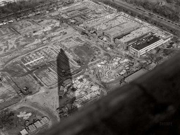 Photo showing: Washingtons Shadow -- March 1942. Washington, D.C. Construction of temporary war emergency
buildings on the Mall, seen from the top of the Washington Monument.