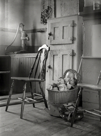 Photo showing: Kitchen Nightmare -- August 1940. Dolls in crib next to icebox of kitchen in Provincetown, Massachusetts.