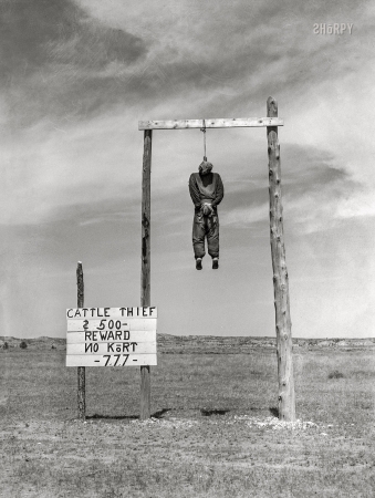 Photo showing: No Kort -- June 1939. Custer County, Montana. Cattle thief hanged in effigy to provide
Western atmosphere for tourists. '777' refers to secret password of vigilantes in 1864.