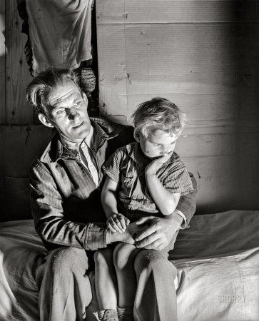 Photo showing: Cardboard Cabin -- November 1939. Butler County, Missouri. Evicted sharecropper and son in makeshift home.