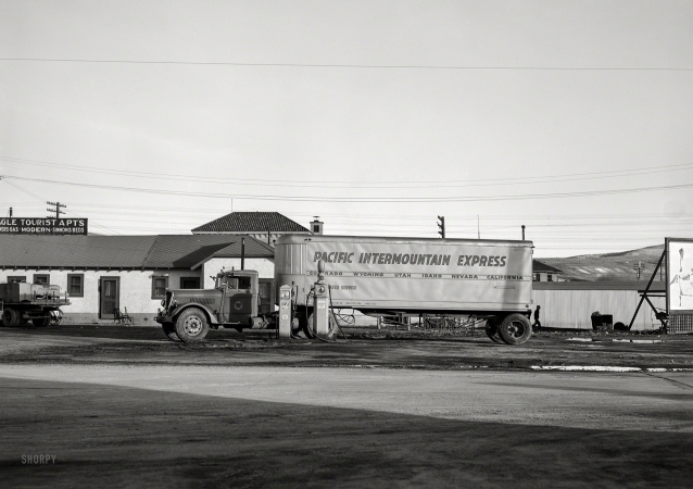 Photo showing: Pacific Intermountain Express -- March 1940. Trailer truck at gas station. Elko, Nevada.