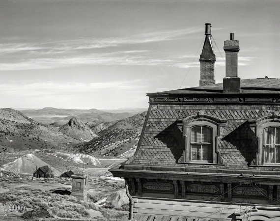 Photo showing: A Roof With a View -- March 1940. Corner of old mine office, abandoned mines in distance. Virginia City, Nevada.