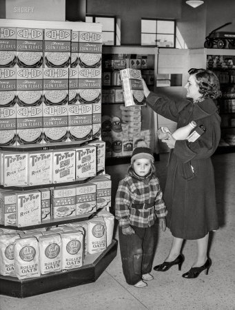 Photo showing: Fancy Flakes -- February 1938. Resident at Greenbelt, Maryland, with child in the cooperative grocery store.