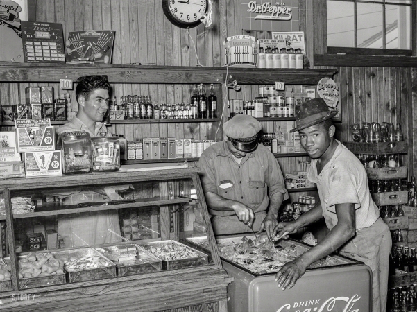Photo showing: The Icing on the Coke -- October 1938. Icing soft drink refrigerator in general store of the Lake Dick Project near Altheimer, Arkansas.