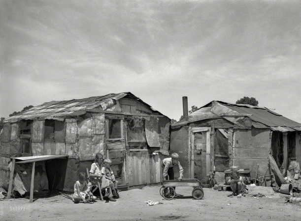 Photo showing: Cozy Shack -- July 1939. Family in front of shack home. May Avenue camp, Oklahoma City.
