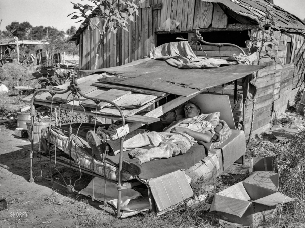 Photo showing: Poor Guy -- July 1939. Bed with roof over it in May Avenue camp, Oklahoma City.
