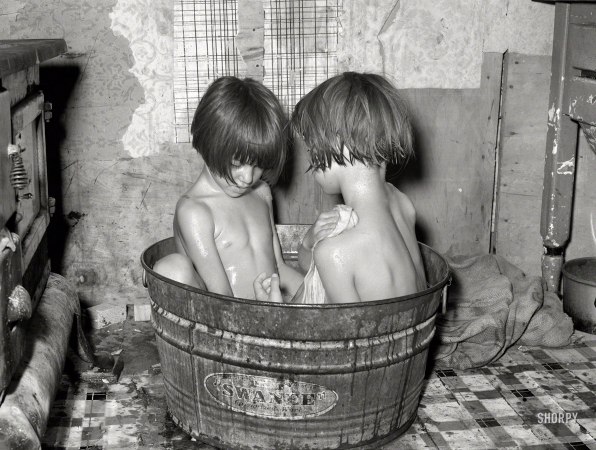 Photo showing: Tub Tots -- July 1939. Oklahoma City. Children taking bath in their home in May Avenue community camp.