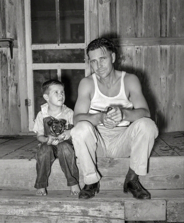 Photo showing: Larger Than Life -- August 1939. Oilfield truck driver and his son sitting on front porch. Seminole, Oklahoma.