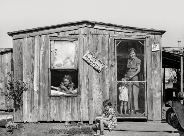 Photo showing: Washings and Iornings -- August 1939. Home and family of oil field roustabout in Oklahoma City.
During periods of unemployment the woman takes in washing and ironing.